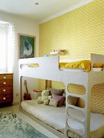 Bunk beds against wall with yellow retro-patterned wallpaper in children's bedroom