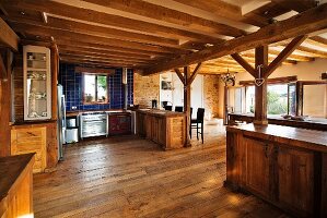 Spacious, country-house kitchen and dining area with wood-beamed ceiling and supporting structure