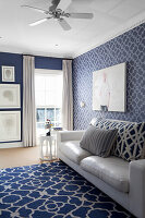 Living room with white leather sofa and blue patterned carpet