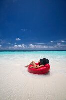 Woman relaxing on beanbag on Maldives beach