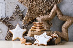 Iced, star-shaped Christmas cookies on old book with Christmas decorations