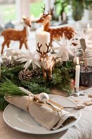 Weihnachtliche Tischdeko, auf Gedeck geschmückte Stoffserviette mit Kiefernzweig und Silberkugel