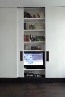TV and bookcase behind simple, white, sliding doors
