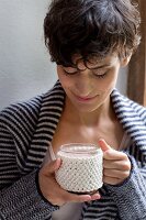 A hand-knitted cup sleeve made of cotton yarn