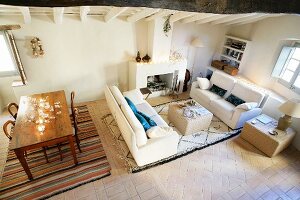 Gemütlicher Loungebereich mit offenem Kamin und antikem Holztisch in restauriertem Altbau mit südländischem Flair