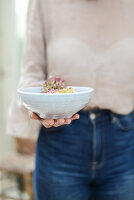 Woman holding bowl of hydrangea flowers