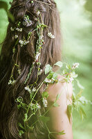 Mädchen mit feenhaftem Wildblumenschmuck im Haar