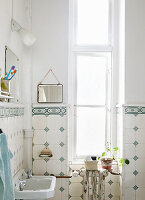 Bright bathroom with vintage tiles and plants by window