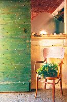 Retro chair on terrazzo floor next to green studded door