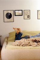 Person and two cats lying on double bed