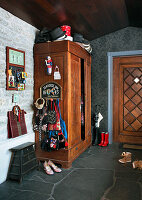 Garderobe an einem alten Schrank im Eingangsbereich mit Steinboden