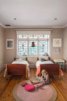 Kinderschlafzimmer mit zwei Einzelbetten und Buntglasfenstern