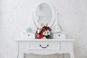 Weisser Frisiertisch mit Spiegelaufsatz und romantischem Blumenstauss