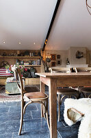 Esstisch aus Holz und Stühle auf schwarzem Fliesenboden in umgebauter Scheune