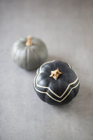 Pumpkins painted grey, one with zig-zag pattern