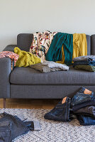 Clothing on a grey upholstered sofa
