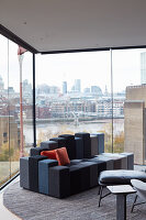 Modern living room with panoramic city view through glass walls