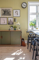 Vintage-Sideboard und Bilderwand im Esszimmer mit Designerstühlen