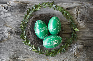 Hand-painted green Easter eggs in wreaths of box and willow