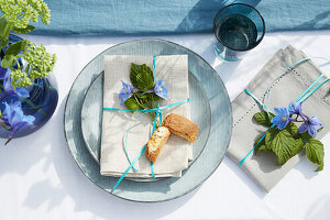 Plates and linen napkins with blue flowers and ribbons