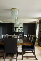Formal dining room with black walls and art deco chandeliers