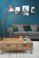 Living room with grey sofa, coffee table and petrol-blue wall