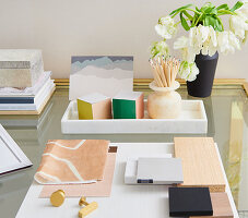 Flowers and stationary on top of brass and glass desk