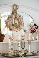 DIY paper wreath on mirror, tray with silver candle holders in foreground