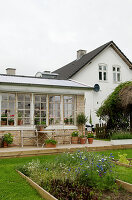 Terrasse am Wintergarten mit Sprossenfenstern, Beete im Garten