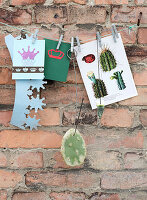 Paper crown, greeting card, and a leaf of a prickly pear on a string