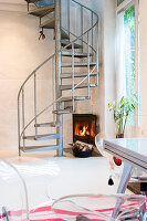 A corner fireplace under a metal spiral staircase