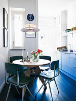 Retro chairs at the round table in a dine-in Kitchen with a dark wooden floor