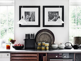 Schwarz-weiße Fotos an der Wand und Pendelleuchten über Küchenzeile