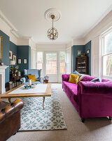 Pinkes Sofa im klassischen Wohnzimmer im Altbau mit Erker