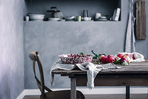 Apples and vintage enamel bowl on wooden table in country-house kitchen
