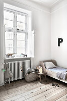 Wooden bed and letter P on white wall in child's bedroom