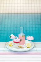 Summery pink cocktail with candy floss next to swimming pool