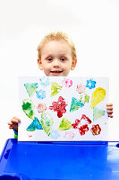 Little boy proudly presenting his potato-print picture