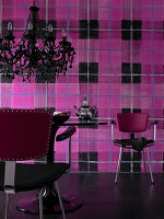 Tulip table and black chandelier in front of wall with wallpaper in oversized pink-and-black tartan pattern