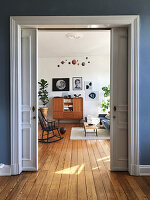Blick durch offene Schiebetür ins Wohnzimmer im Vintage-Stil