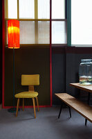Standard lamp next to yellow chair in dining room with accents of colour