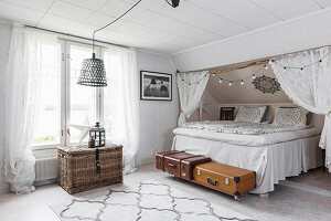 Bett mit Husse unter der Dachschräge im Schlafzimmer mit Bohoflair