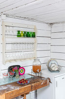 Glasses on plate rack in kitchen with board walls and workbench
