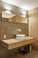 Sink on floating wooden washstand in bathroom