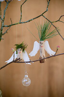 Engel aus Holz mit Papierflügeln und Haaren aus Kiefernadeln und Moos