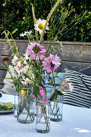 Meadow flowers in water glasses as a summer table decoration