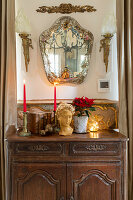 Bust, candle and poinsettia on old cabinet