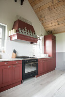 A red-brown kitchen work surface in a room with a high ceiling