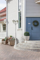 Traditionelles, weißes Holzhaus mit blauer Eingangstür