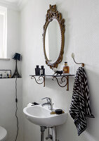 Antiker Spiegel und Regal im weißen Bad mit Strukturtapete